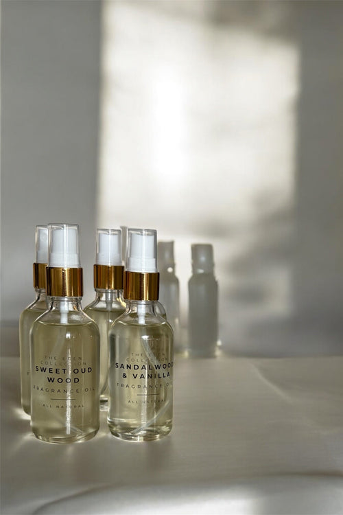 Set of perfume bottles with gold caps on a light surface with soft shadows