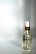 Sandalwood & Vanilla fragrance oil bottle on a reflective surface with a gradient background