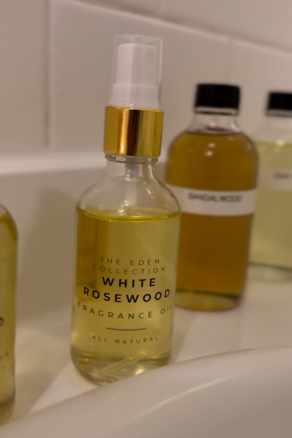 Bottle of White Rosewood fragrance oil from The Eden Collection on a bathroom counter.