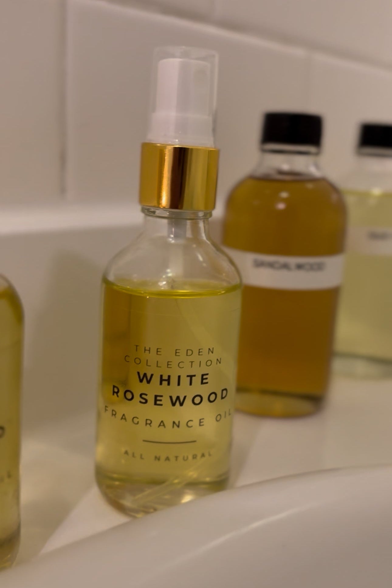 Bottle of White Rosewood fragrance oil from The Eden Collection on a bathroom counter.